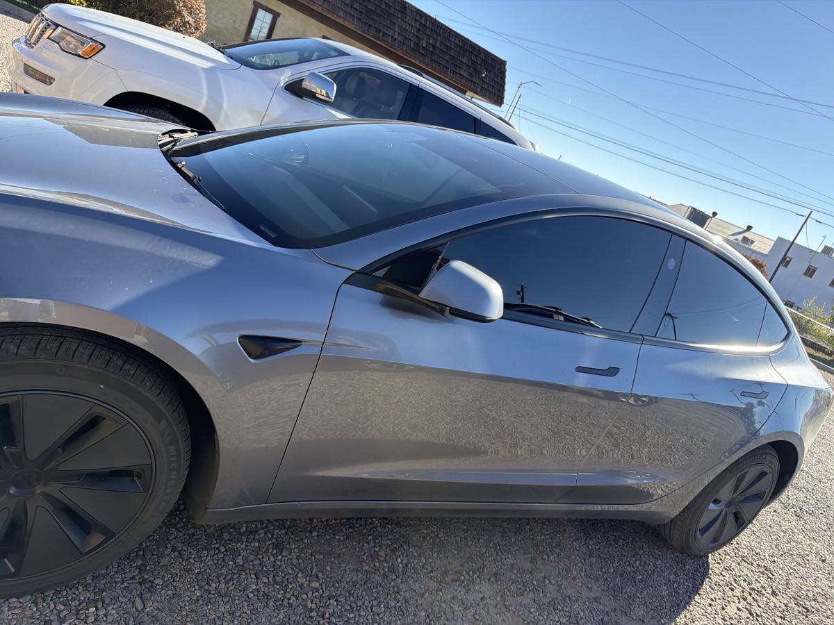 A grey Tesla with freshly tinted windows at Fade To Black, LLC