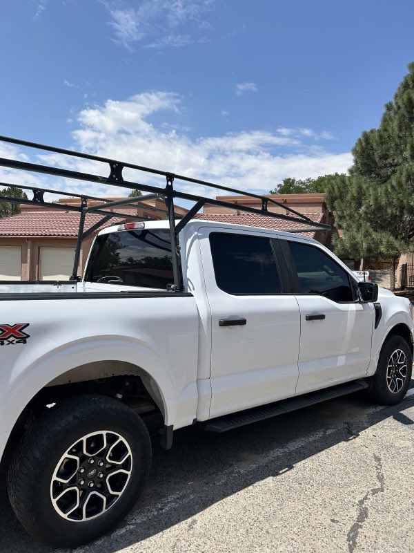 Tinted white F-150 work truck with ladder rack
